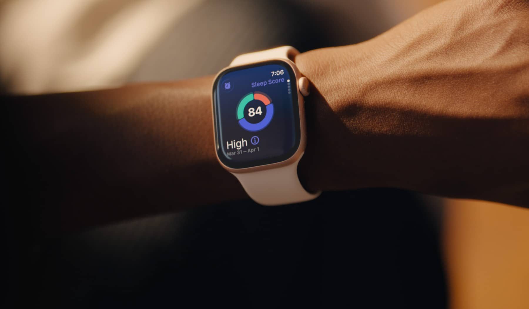 Smartwatch on a wrist showing a sleep score of 84