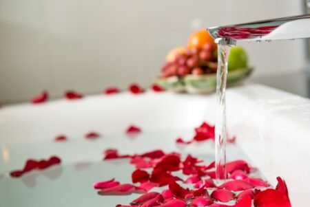 Bath tub filled water rose petals