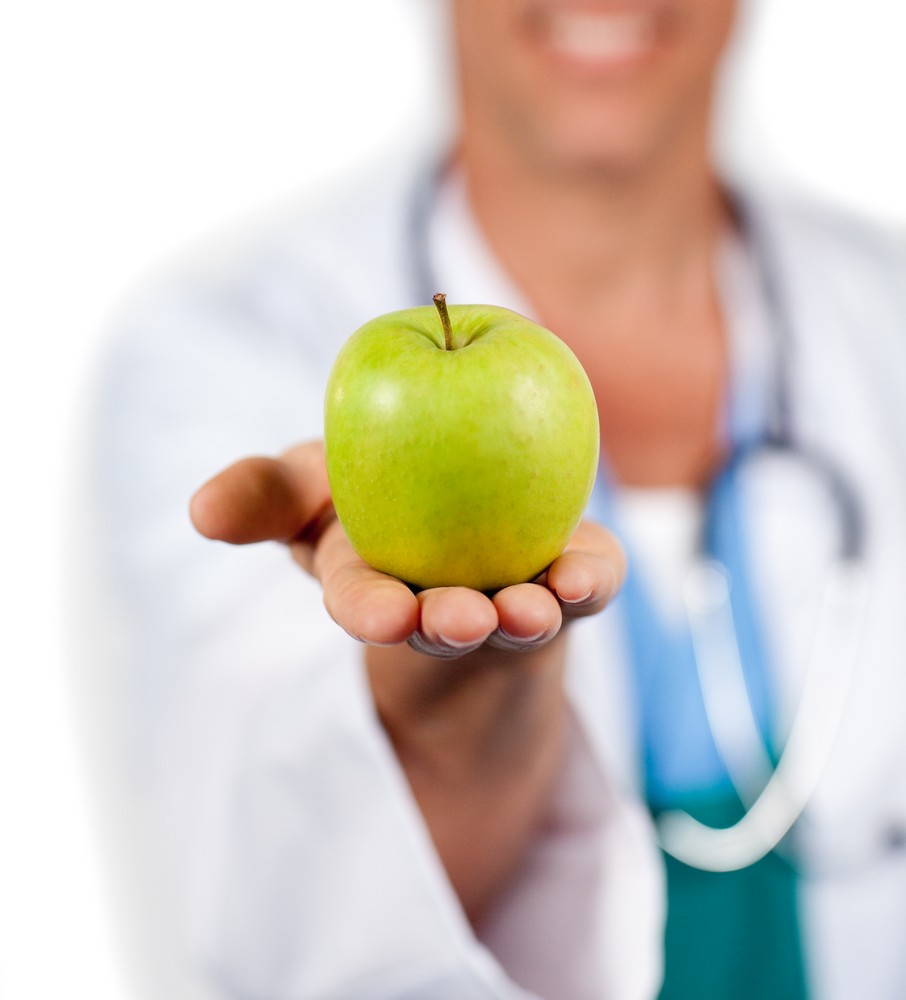 Doctor holding green apple his hand