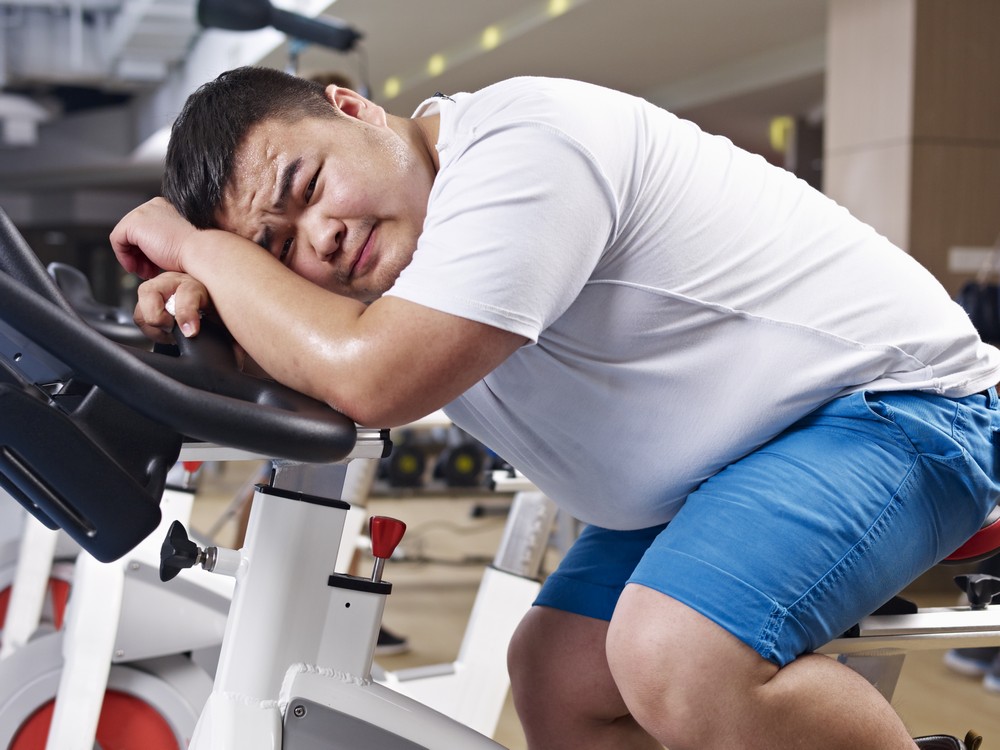 Man is sitting stationary bike