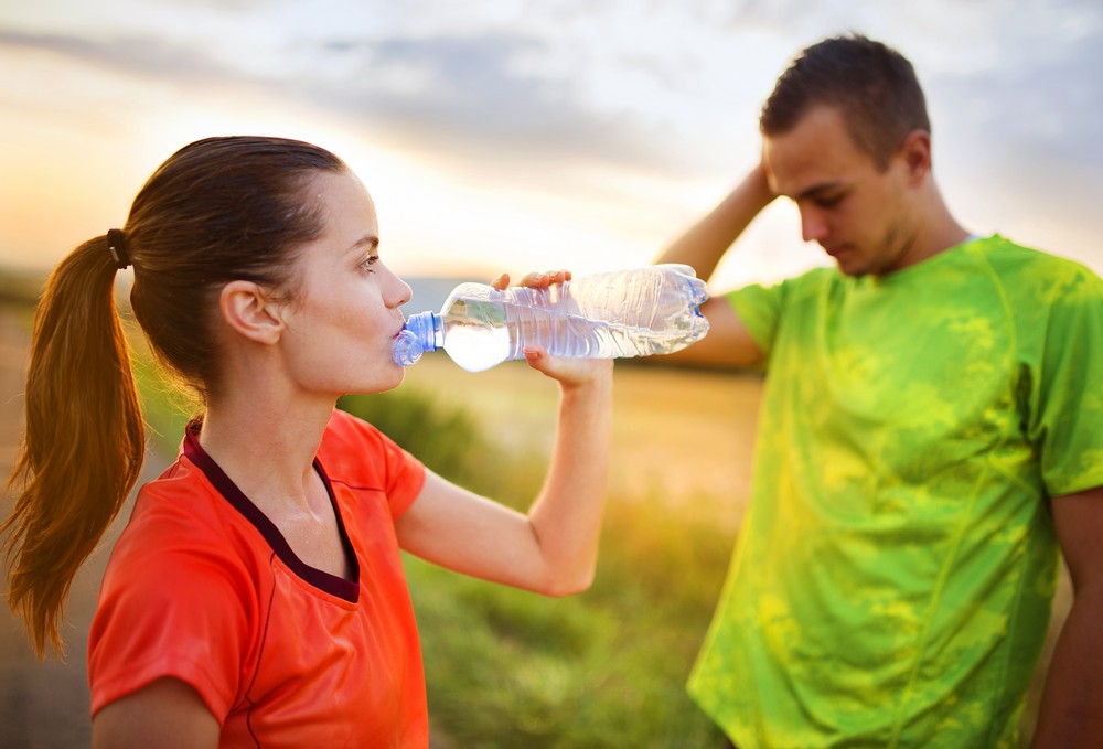 Man woman drinking water bottle