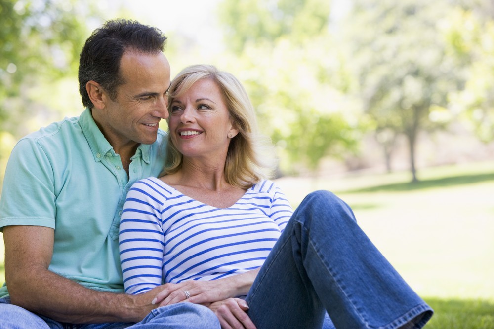 Man woman sitting blanket grass