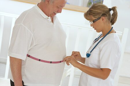 Nurse measuring patient's waist tape