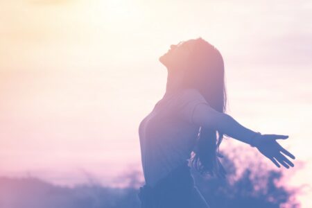 Woman is standing sun her arms outstretched