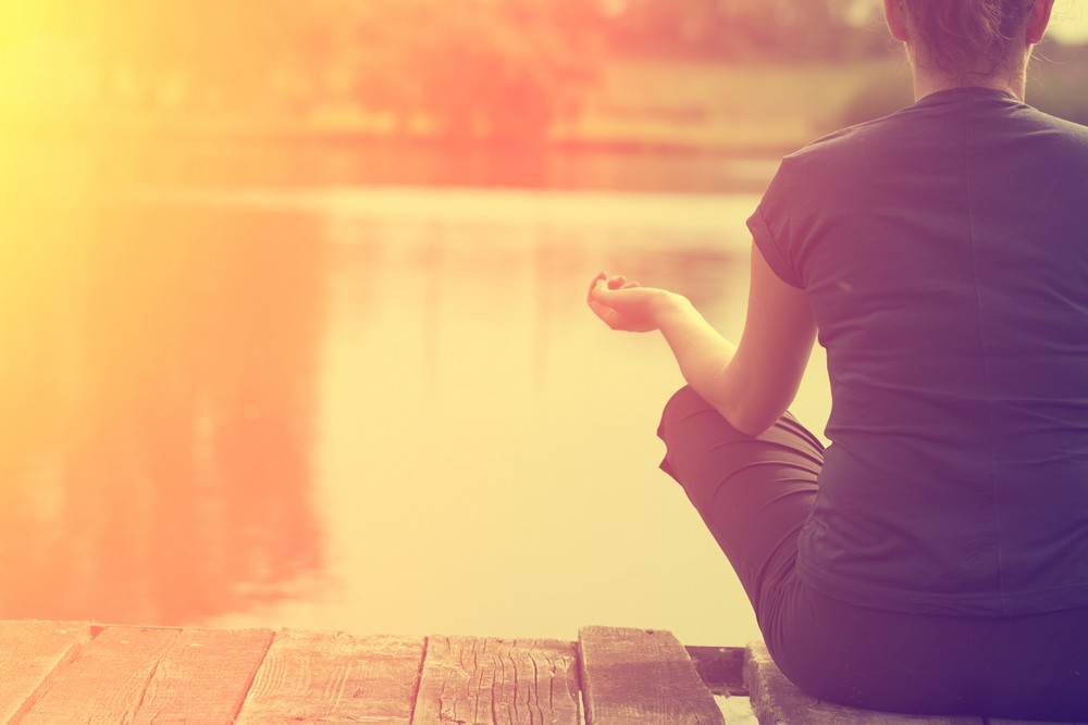 Woman sitting dock her hands air